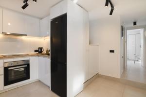 a kitchen with white cabinets and a black refrigerator at Castelo View Luxury apt in Rhodes Town +19 photos