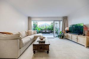 a living room with a couch and a flat screen tv at 'La Palma', Sunshines Heart beside The Village in Sunshine Beach