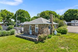 a stone house with a chimney on a yard at Marina Bay Cottages in Waterford