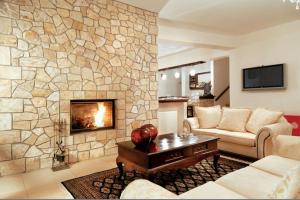 a living room with a couch and a fireplace at Vytina Mountain View Hotel in Vitina