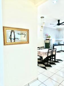 a kitchen and dining room with a table and chairs at ROSHUS HOMESTAY MELAKA in Ayer Keroh