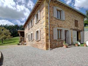 a brick house with a gravel driveway in front of it at Charmant Gîte Cocooning avec Terrasse et Animaux Acceptés - FR-1-496-306 in Belmont-de-la-Loire