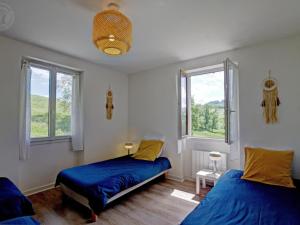 a bedroom with two beds and two windows at Charmant Gîte Cocooning avec Terrasse et Animaux Acceptés - FR-1-496-306 in Belmont-de-la-Loire