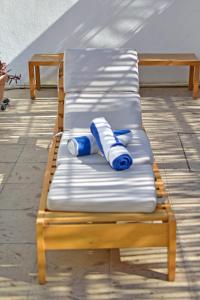 a wooden bench with blue and white pillows on it at Casa Palo Verde in Cabo San Lucas