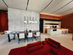 a living room with a table and a red couch at Citadines Yazhou Bay Sanya in Sanya
