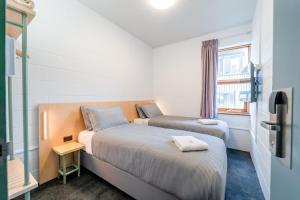 two beds in a small room with a window at YHA Thredbo in Thredbo