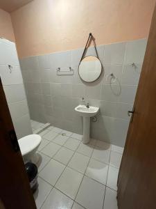 a bathroom with a toilet and a sink at Bertioga Rio da Praia in Bertioga