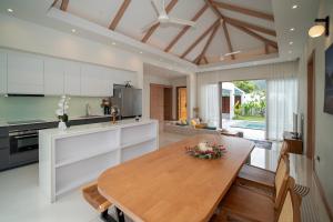 a kitchen with a wooden table and a dining room at Villa Anastasia Aonang in Ao Nang 