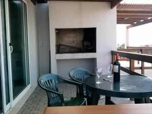 a table and chairs with a bottle of wine and wine glasses at Yavé Yireh in Punta Del Diablo