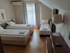 una camera d'albergo con due letti e un tavolo di Hostel Tema Nova Centar a Čačak