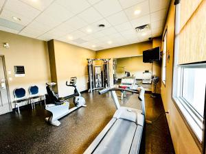 ein Fitnessstudio mit Laufbändern und Geräten in einem Raum in der Unterkunft Beaverlodge Motor Inn in Beaverlodge