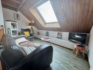a living room with a couch and a tv at Appartement rénové 3 pièces, vue mer, 4 couchages, Wifi, St-Trojan-les-Bains - FR-1-246A-315 in Saint-Trojan-les-Bains