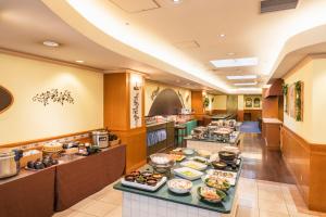 a buffet line in a restaurant with food on display at Hotel Sunroute Niigata in Niigata