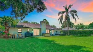 a house with a green yard with a palm tree at 7 Room TampaGolfVillas by AmericanVacationliving in Wesley Chapel