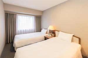 Postel nebo postele na pokoji v ubytování Hotel Sunroute Niigata