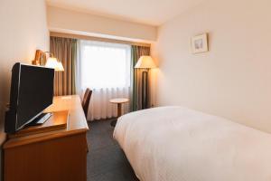 Postel nebo postele na pokoji v ubytování Hotel Sunroute Niigata