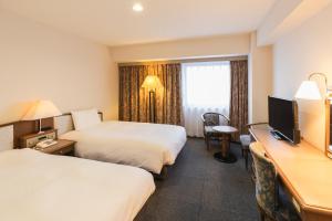 Postel nebo postele na pokoji v ubytování Hotel Sunroute Niigata
