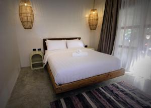 a bedroom with a large bed with a towel on it at Casavia Siargao in Catangnan