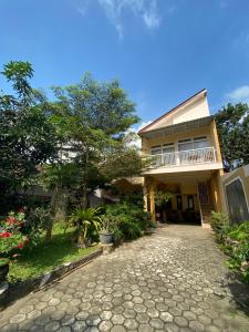 Una casa con un camino de piedra al frente. en Luchis HOME Ijen, en Banyuwangi