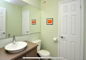 ein Badezimmer mit Waschbecken, Toilette und Spiegel in der Unterkunft Super Condo ski et vélo 2 min Mont-Ste-Anne in Beaupré + 16 Fotos