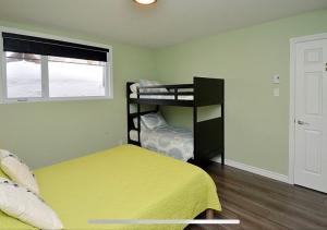 ein Zimmer mit zwei Betten und einem Etagenbett in der Unterkunft Super Condo ski et vélo 2 min Mont-Ste-Anne in Beaupré
