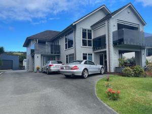two cars parked in front of a house at Lang's Beach Luxury Apartment in Langs Beach