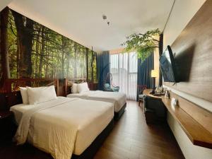 a hotel room with two beds and a flat screen tv at Hemangini Hotel Bandung in Bandung