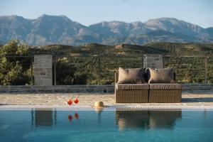 a couch sitting on the edge of a swimming pool at Villa Ida in Kamilari