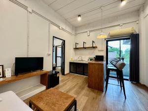 a living room with a television and a kitchen at The51Hometel in Chiang Mai