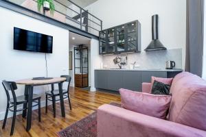 a living room with a pink couch and a table at Dream Stay - Modern City Centre Lofts with Self Check-in in Tallinn