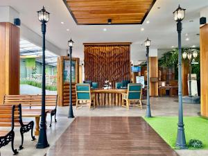a lobby with benches and a table with blue chairs at Hemangini Hotel Bandung in Bandung