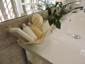 ein Waschbecken im Badezimmer mit einer Vase mit einer Blume darauf in der Unterkunft Anfiteatro Suite in Rom