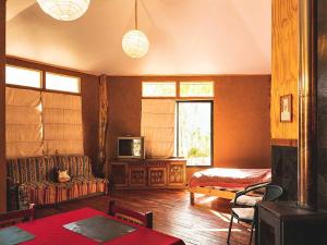 a living room with a couch and a tv at elquiwellness Cochiguaz in Cochiguaz
