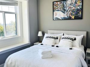 a bedroom with a white bed and a window at Jennifer's House in Vancouver