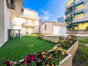 un jardin fleuri au milieu d'un bâtiment dans l'établissement Apartments in Bibione 45652, à San Michele al Tagliamento