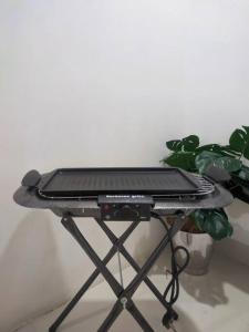 a laptop on a stand next to a plant at Relax & Chill 4BR Terrace House in Batam Center