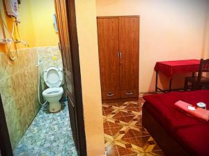 een badkamer met een toilet, een kast en een bed bij DD Guest House in Pakse
