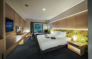a hotel room with a large bed and a desk at Noku Kyoto in Kyoto