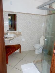 y baño con aseo, lavabo y ducha. en Pousada Arraial Suites, en Arraial d'Ajuda