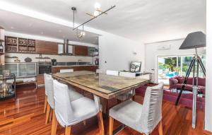 a kitchen and dining room with a wooden table and chairs at Beach Front Home In Punat With Kitchen in Punat