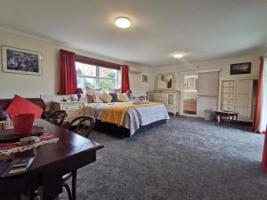 a bedroom with a bed and a desk and a table at Geyser Lookout BnB in Rotorua +256 photos