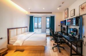 a bedroom with a bed and a desk with a computer at Muyu E-SPORT HOTEL慕鱼电竞酒店 in Chongqing