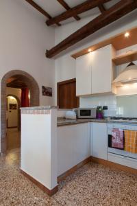 cocina con armarios blancos y encimera en Ve-nice Suite Giuffa C4834, en Venecia