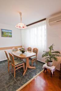 uma sala de jantar com uma mesa e cadeiras e um vaso de plantas em Apartment Tennis em Split