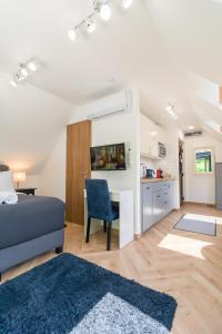 a living room with a blue couch and a kitchen at Monbuhim Comfort in Veszprém