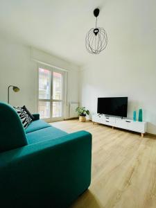a living room with a blue couch and a flat screen tv at Joy Apartment in Savona
