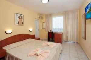 a bedroom with a bed with bows on it at Family Hotel Andreev in Nesebar +37 photos