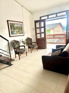 a living room with a couch and chairs and a door at Apartamento cerca al parque in Jardin