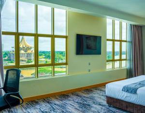 クチンにあるThe Waterfront Hotel Kuchingのベッドと大きな窓が備わるホテルルームです。