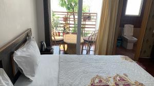 a bedroom with a bed and a balcony at Rudram Hotel Yoga & Ayurveda Retreat in Rishīkesh